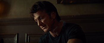 Movie still from “The Gunman” (2015), directed by Pierre Morel – A person wearing a black t - shirt; Close Up shot, Low angle