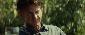 Movie still from “The Gunman” (2015), directed by Pierre Morel – A person wearing a shirt; Close Up shot, Over the shoulder angle