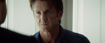 Movie still from “The Gunman” (2015), directed by Pierre Morel – A person wearing a blue shirt; Close Up shot, Over the shoulder angle