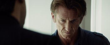 Movie still from “The Gunman” (2015), directed by Pierre Morel – A person looking at the camera; Close Up shot, Over the shoulder angle