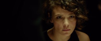 Movie still from “The Gunman” (2015), directed by Pierre Morel – A person with curly hair; Close Up shot, Over the shoulder angle