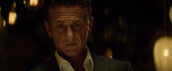 Movie still from “The Gunman” (2015), directed by Pierre Morel – A person wearing a suit and tie; Close Up shot, Low angle