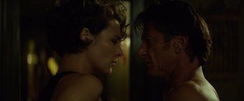 Movie still from “The Gunman” (2015), directed by Pierre Morel – A man and a woman face to face in the dark; Close Up shot, Over the shoulder angle