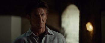 Movie still from “The Gunman” (2015), directed by Pierre Morel – A person wearing a white shirt; Close Up shot, Low angle