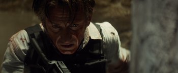 Movie still from “The Gunman” (2015), directed by Pierre Morel – A person with a gun in his hand; Close Up shot, Low angle