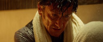 Movie still from “The Gunman” (2015), directed by Pierre Morel – A person with a towel around his neck; Close Up shot, Low angle