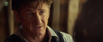 Movie still from “The Gunman” (2015), directed by Pierre Morel – A person wearing a shirt and tie; Close Up shot, Over the shoulder angle