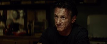 Movie still from “The Gunman” (2015), directed by Pierre Morel – A person wearing a t - shirt; Close Up shot, Over the shoulder angle