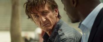 Movie still from “The Gunman” (2015), directed by Pierre Morel – A person wearing a jacket; Close Up shot, Over the shoulder angle