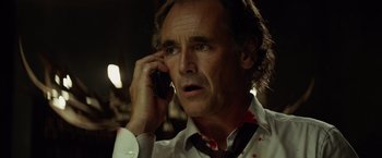 Movie still from “The Gunman” (2015), directed by Pierre Morel – A person talking on a cell phone; Close Up shot, Low angle