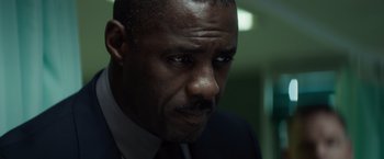 Movie still from “The Gunman” (2015), directed by Pierre Morel – A person wearing a suit and tie; Close Up shot, Low angle