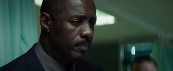 Movie still from “The Gunman” (2015), directed by Pierre Morel – A person wearing a suit and tie; Close Up shot, Low angle