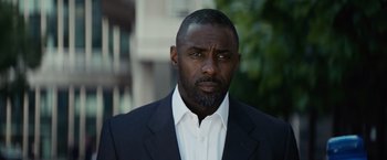 Movie still from “The Gunman” (2015), directed by Pierre Morel – A person wearing a suit and tie; Close Up shot, Low angle