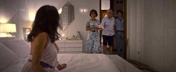 Movie still from “The Hand of God” (2021), directed by Paolo Sorrentino – Three people standing in a room looking at a bed; Medium shot, Over the shoulder angle