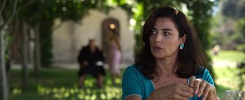 Movie still from “The Hand of God” (2021), directed by Paolo Sorrentino – A woman sitting on a bench in the grass; Close Up shot, Over the shoulder angle