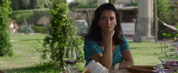 Movie still from “The Hand of God” (2021), directed by Paolo Sorrentino – A woman sitting at an outdoor table with a glass of wine; Medium shot, Over the shoulder angle