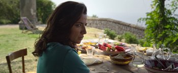 Movie still from “The Hand of God” (2021), directed by Paolo Sorrentino – A woman sitting at a table with a plate of food on top of it; Close Up shot, Over the shoulder angle