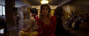A woman in a red dress smoking a cigarette