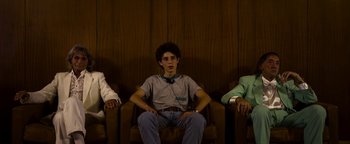 Movie still from “The Hand of God” (2021), directed by Paolo Sorrentino – A group of people sitting in a row of chairs; Medium shot, Low angle