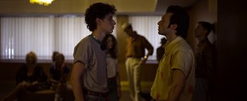 Movie still from “The Hand of God” (2021), directed by Paolo Sorrentino – Two young men talking to each other in a room; Medium shot, Over the shoulder angle