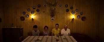 Movie still from “The Hand of God” (2021), directed by Paolo Sorrentino – A group of people sitting around a table; Wide shot, High angle