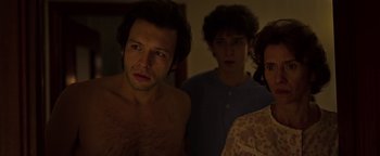 Movie still from “The Hand of God” (2021), directed by Paolo Sorrentino – A group of people standing next to each other in a room; Medium shot, Over the shoulder angle