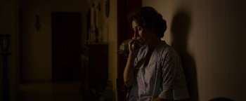 Movie still from “The Hand of God” (2021), directed by Paolo Sorrentino – A woman is talking on a phone in a room; Medium shot, High angle