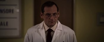 Movie still from “The Hand of God” (2021), directed by Paolo Sorrentino – A man in a white lab coat and a red neck tie; Close Up shot, Low angle