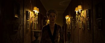 Movie still from “The Hand of God” (2021), directed by Paolo Sorrentino – An older woman standing in a dark hallway; Medium shot, Low angle