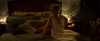 Movie still from “The Hand of God” (2021), directed by Paolo Sorrentino – An older woman sitting on the floor in a white dress; Medium shot, Over the shoulder angle