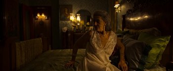 Movie still from “The Hand of God” (2021), directed by Paolo Sorrentino – An older woman sitting on a bed in a room; Medium shot, Over the shoulder angle