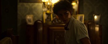 Movie still from “The Hand of God” (2021), directed by Paolo Sorrentino – A young man with curly hair wearing a tie; Close Up shot, Over the shoulder angle