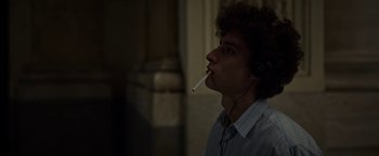 Movie still from “The Hand of God” (2021), directed by Paolo Sorrentino – A man smoking a cigarette while listening to music; Close Up shot, Low angle