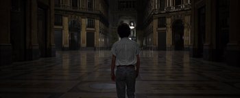 Movie still from “The Hand of God” (2021), directed by Paolo Sorrentino – A man standing in the middle of an empty hallway; Wide shot, High angle