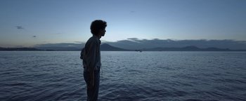 Movie still from “The Hand of God” (2021), directed by Paolo Sorrentino – A man standing in the water looking at the ocean; Medium shot, Low angle
