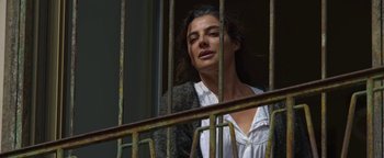 Movie still from “The Hand of God” (2021), directed by Paolo Sorrentino – A woman standing behind bars looking out of a window; Close Up shot, Low angle