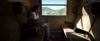 Movie still from “The Hand of God” (2021), directed by Paolo Sorrentino – A man sitting on a train looking out the window; Medium shot, High angle