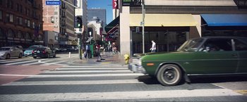 Movie still from “The Happytime Murders” (2018), directed by Brian Henson – A car drives down a street in a city; Wide shot, High angle