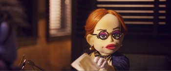 Movie still from “The Happytime Murders” (2018), directed by Brian Henson – The face of a doll with glasses; Close Up shot, Over the shoulder angle