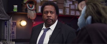 Movie still from “The Happytime Murders” (2018), directed by Brian Henson – A man wearing a suit and tie in a room; Close Up shot, Over the shoulder angle