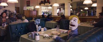 Movie still from “The Happytime Murders” (2018), directed by Brian Henson – Two people sitting at a table in a restaurant with masks on; Medium shot, Over the shoulder angle