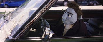 Movie still from “The Happytime Murders” (2018), directed by Brian Henson – A person in a suit and mask driving in a car; Medium shot, Over the shoulder angle