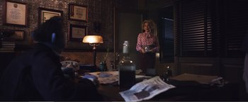 Movie still from “The Happytime Murders” (2018), directed by Brian Henson – A woman standing in front of a mirror holding a bowl; Medium shot, Low angle