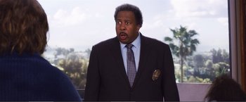 Movie still from “The Happytime Murders” (2018), directed by Brian Henson – A person wearing a suit and tie; Close Up shot, Over the shoulder angle