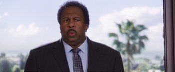 Movie still from “The Happytime Murders” (2018), directed by Brian Henson – A person wearing a suit and tie; Close Up shot, Over the shoulder angle