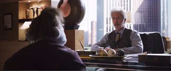 Movie still from “The Happytime Murders” (2018), directed by Brian Henson – An older man sitting at a table with a woman; Close Up shot, Over the shoulder angle