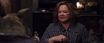 Movie still from “The Happytime Murders” (2018), directed by Brian Henson – A person sitting at a table with a bottle; Close Up shot, Over the shoulder angle