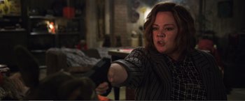 Movie still from “The Happytime Murders” (2018), directed by Brian Henson – A woman holding a gun in a room; Medium shot, Over the shoulder angle