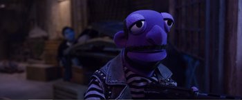 Movie still from “The Happytime Murders” (2018), directed by Brian Henson – A person wearing a purple puppet with a leather jacket; Close Up shot, High angle