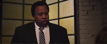 Movie still from “The Happytime Murders” (2018), directed by Brian Henson – A man wearing a suit and tie in front of a window; Close Up shot, Over the shoulder angle